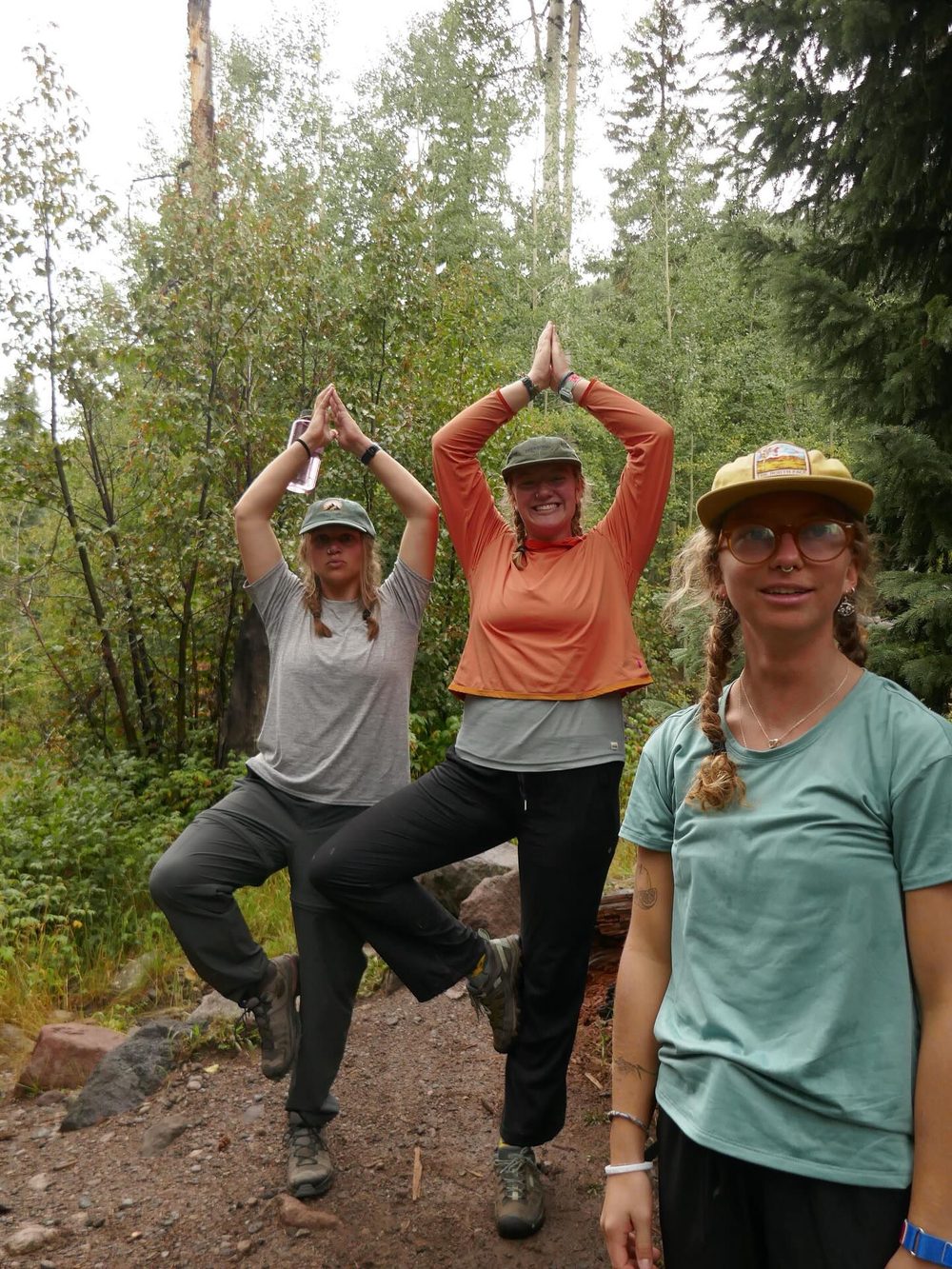 Students doing a balance pose on a forest trail
