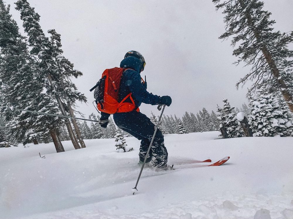 A skier making a turn in fresh powder in the backcountry